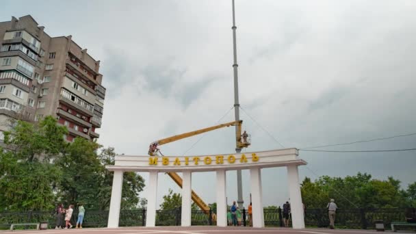 Oekraïne, Melitopol, augustus 2019. Installatie van een vlaggenmast met de Oekraïense staat vlag op het centrale plein van de stad. — Stockvideo