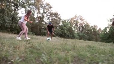Ebeveynleri ve aile arkadaşları olan bir çocuk orman glade bir top oynar.