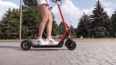 Elektrikli scooter kullanan bir kız olan bir adam.
