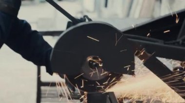İşçi metal parçaları kesiyor. Metal kesim sırasında demirden kıvılcımlar.