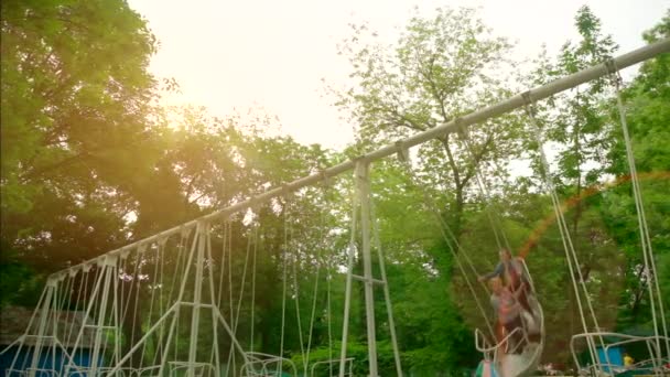 Deux jeunes filles s'amusent à se balancer sur des attractions de type bateau. — Video