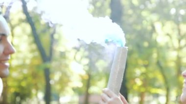 Hamile kadın mavi duman bombası tutuyor. Ailesiyle birlikte seviniyor. Cinsiyet Partisi