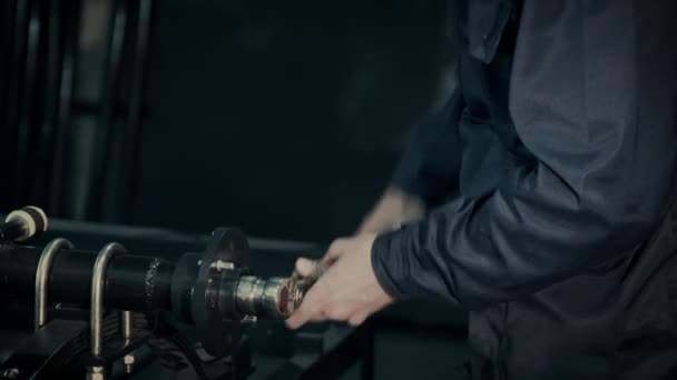 Dělník otáčí ložiskem v náboji kola v montážní dílně — Stock video