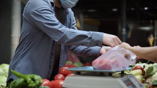 Homme en masque de protection achète des légumes au marché fermier — Video