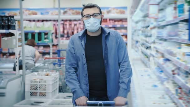 Хлопець в масці для обличчя і окулярах гуляє в супермаркеті — стокове відео