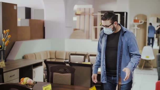 Klant in masker kiest stoelen en tafel voor eetkamer — Stockvideo