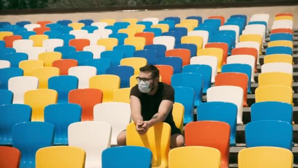 Jeden muž mezi prázdnými diváckými místy na stadionu — Stock video