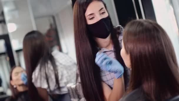 Maskeli vize uzmanı kuaförde müşteri yüzüne makyaj uygular — Stok video