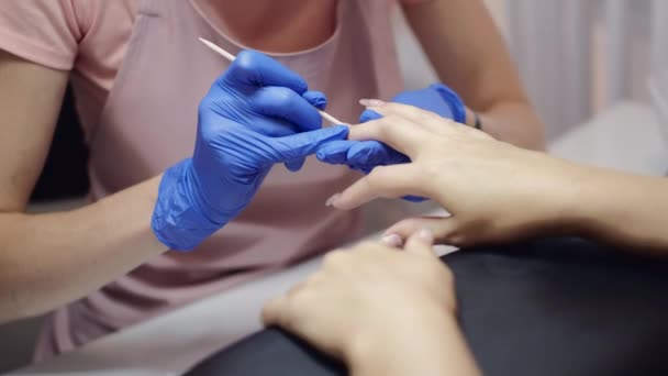 Master in beschermende handschoenen verwijdert klant nagelriemen in salon — Stockvideo