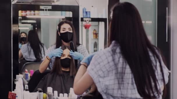 マスクと手袋ブラシサロンのクライアントの髪のスタイリスト — ストック動画