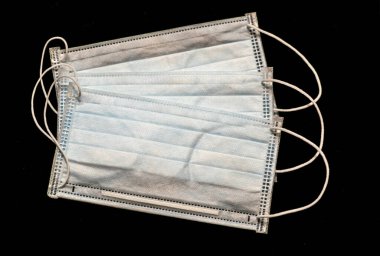 Plastik kulaklıklı cerrahi maske. Ağız ve burnu örtmek için tipik 3 katlı cerrahi maske. Bakterilerin prosedür maskesi. Siyah arkaplanda izole