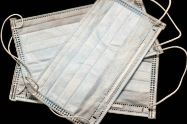 Plastik kulaklıklı cerrahi maske. Ağız ve burnu örtmek için tipik 3 katlı cerrahi maske. Bakterilerin prosedür maskesi. Siyah arkaplanda izole