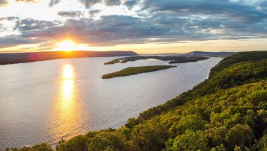 Volga nehri üzerinde yaz günbatımında küçük kum adaları ve tepelerde yeşil ormanlarla hava manzarası, Samara, Rusya 