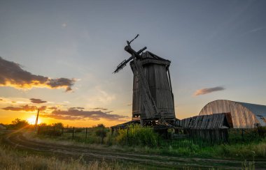 Eski terk edilmiş ahşap değirmen, 19. yüzyılda Rusya 'nın Samara bölgesinde inşa edilmiş. Yaz gün batımı manzarası