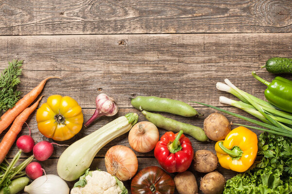 Assorted organic fresh vegetables on wooden table