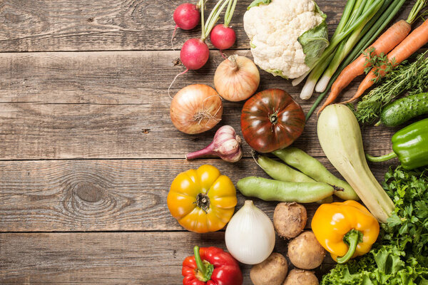 Assorted organic fresh vegetables on wooden table