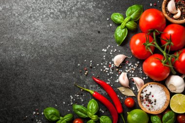 Domates, baharat ve fesleğen siyah arka plan üzerinde yaprakları