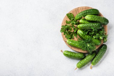 Ahşap kesme tahtası ve mutfak masasında taze salatalık