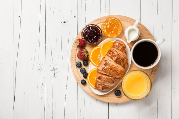 Desayuno con cruasanes, café, zumo de naranja, fruta y berr —  Fotos de Stock
