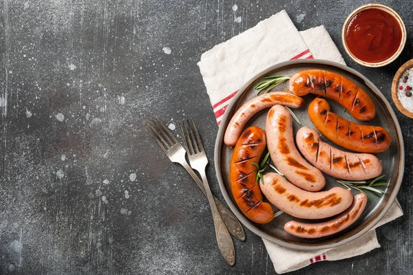 Grilled sausages with ketchup and salt — Stock Photo, Image