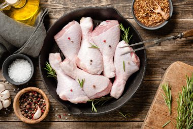 Pişirmek için malzemeli taze çiğ tavuk bacağı.