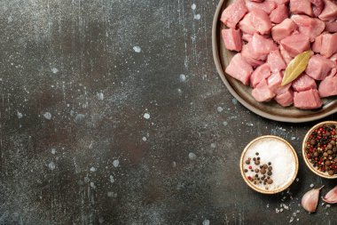 Seramik tabakta taze domuz eti ve pişirmek için baharatlar.