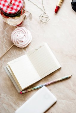 Güzellik düz bir günlük, smartphone, aksesuarları ve peonies mermer bir zemin üzerine yatırın. Üstten görünüm