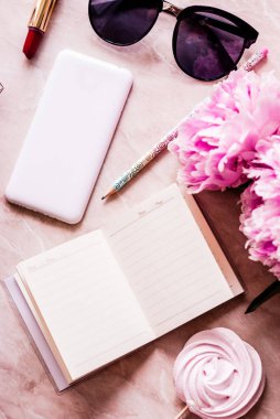 Güzellik düz bir günlük, smartphone, aksesuarları ve peonies mermer bir zemin üzerine yatırın. Üstten görünüm
