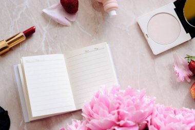 Güzellik düz bir günlük, smartphone, aksesuarları ve peonies mermer bir zemin üzerine yatırın. Üstten görünüm