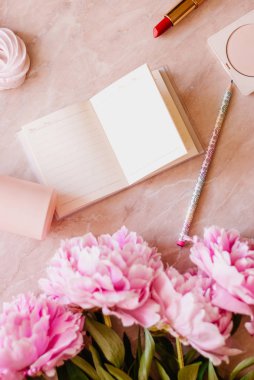 Güzellik düz bir günlük, smartphone, aksesuarları ve peonies mermer bir zemin üzerine yatırın. Üstten görünüm