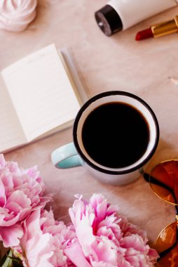 Güzellik düz bir günlüğü, fincan kahve, aksesuarları ve peonies mermer zemin ile yatıyordu. Üstten görünüm
