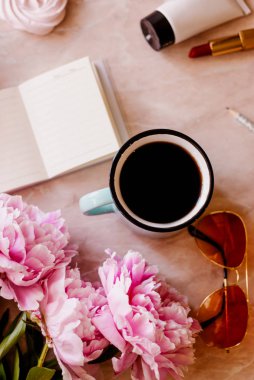 Güzellik düz bir günlüğü, fincan kahve, aksesuarları ve peonies mermer zemin ile yatıyordu. Üstten görünüm