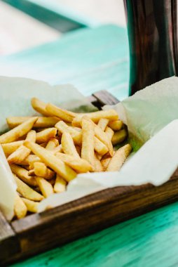 Patates kızartması bir ahşap tahta ve karanlık bira. Sağlıksız yiyecek