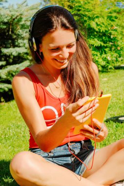 Güzel esmer kadın sarı tablet açık havada kullanma.