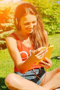 Güzel esmer kadın sarı tablet açık havada kullanma.