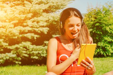 Güzel esmer kadın sarı tablet açık havada kullanma.