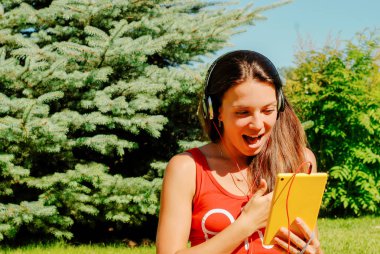 Güzel esmer kadın sarı tablet açık havada kullanma.