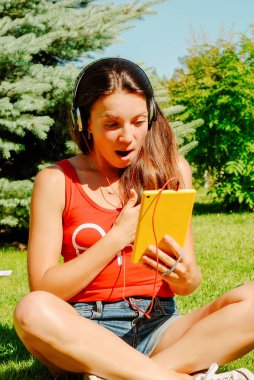 Güzel esmer kadın sarı tablet açık havada kullanma.