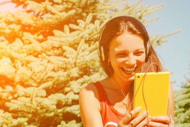 Güzel esmer kadın sarı tablet açık havada kullanma.