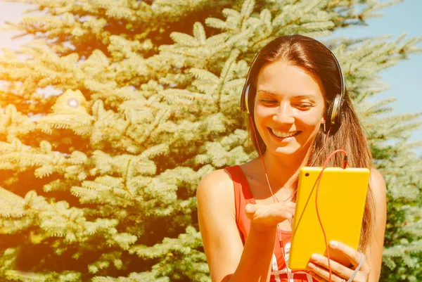 Güzel esmer kadın sarı tablet açık havada kullanma.