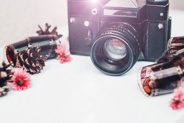 Boş fotoğraf çerçevesi içine, retro kamera, fotoğraf film için rulo ve beyaz arka plan üzerinde çiçekler.
