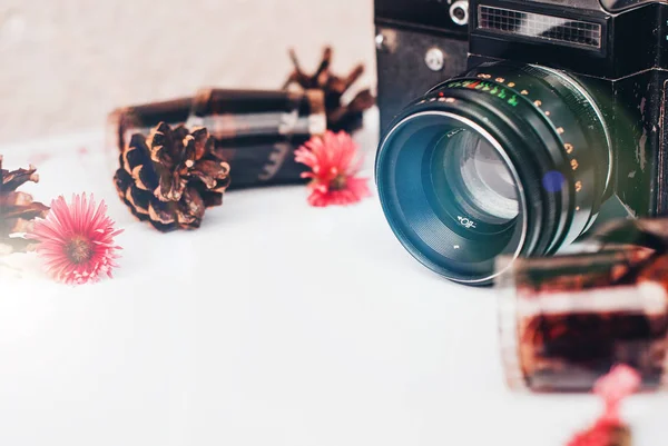 Boş fotoğraf çerçevesi içine, retro kamera, fotoğraf film için rulo ve beyaz arka plan üzerinde çiçekler.