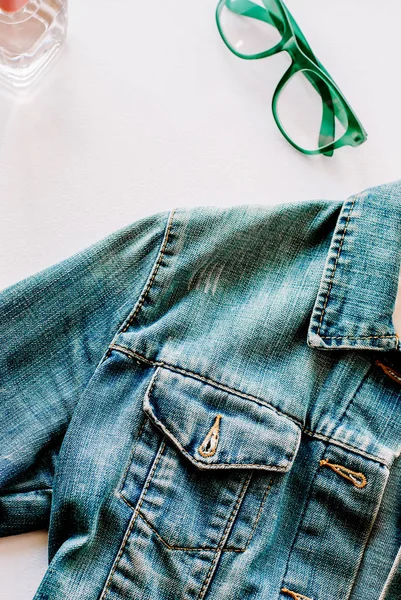 Kot ceket, kolye, parfüm ve yeşil gözlük görünümü top. Düz yatıyordu fotoğraf. Blogger'ın öğeleri moda. Kadınsı arka plan. Bahar, sonbahar satış ve alışveriş kavramı