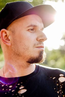 yakışıklı adam açık bir yırtık gömlek ve yenilikçi Cap sakallı