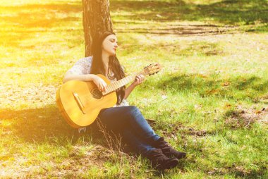 bir akustik gitar açık oynayan kadın