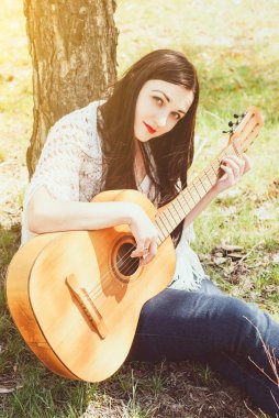 bir akustik gitar açık oynayan kadın