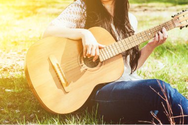 bir akustik gitar açık oynayan kadın