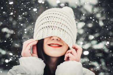 mutlu kadın şapkası örme bir beyaz şapka kafasına çeker..