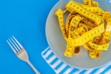 Diyet kavramı. Çatalı tabağa yalan santimetre rewound