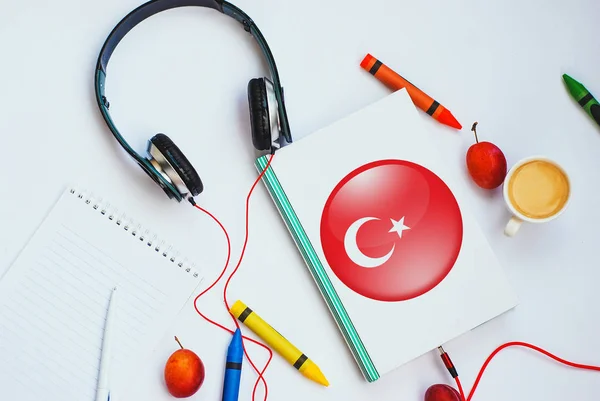 Türk bayrağı ve kulaklık ile kitap. Ses dersler yoluyla Türk öğrenme kavramı